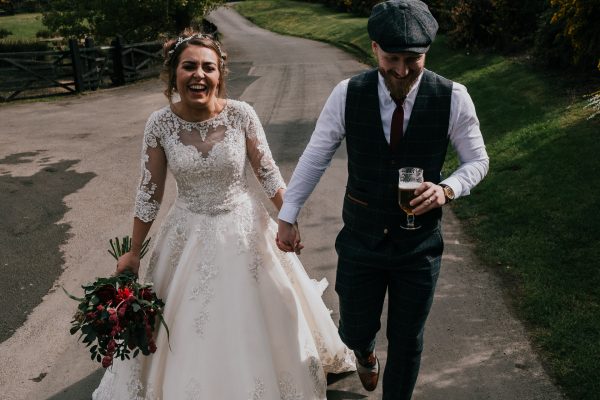 bride and groom walking holding hands at their Northumberland wedding